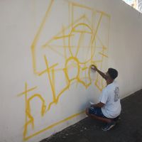 O artista Babu78 produzindo um grafite em memoria das vitimas